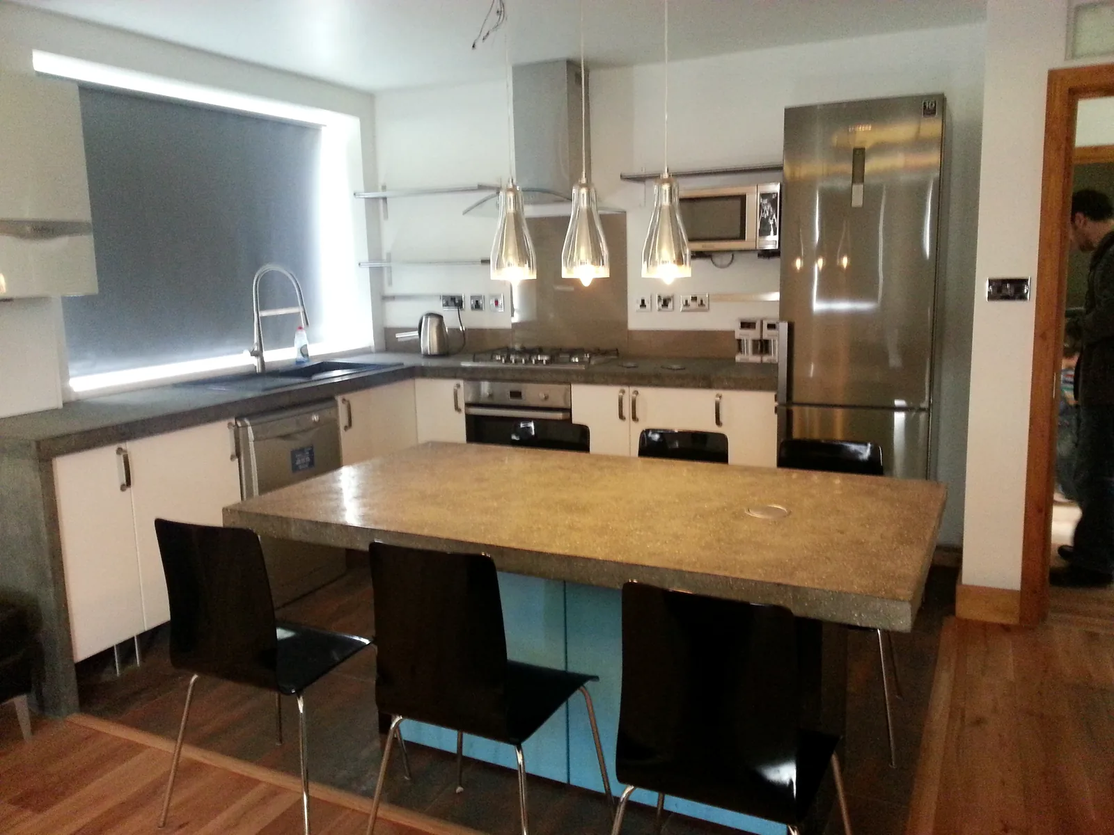 Completed kitchen with central island, pendant lights and integrated appliances