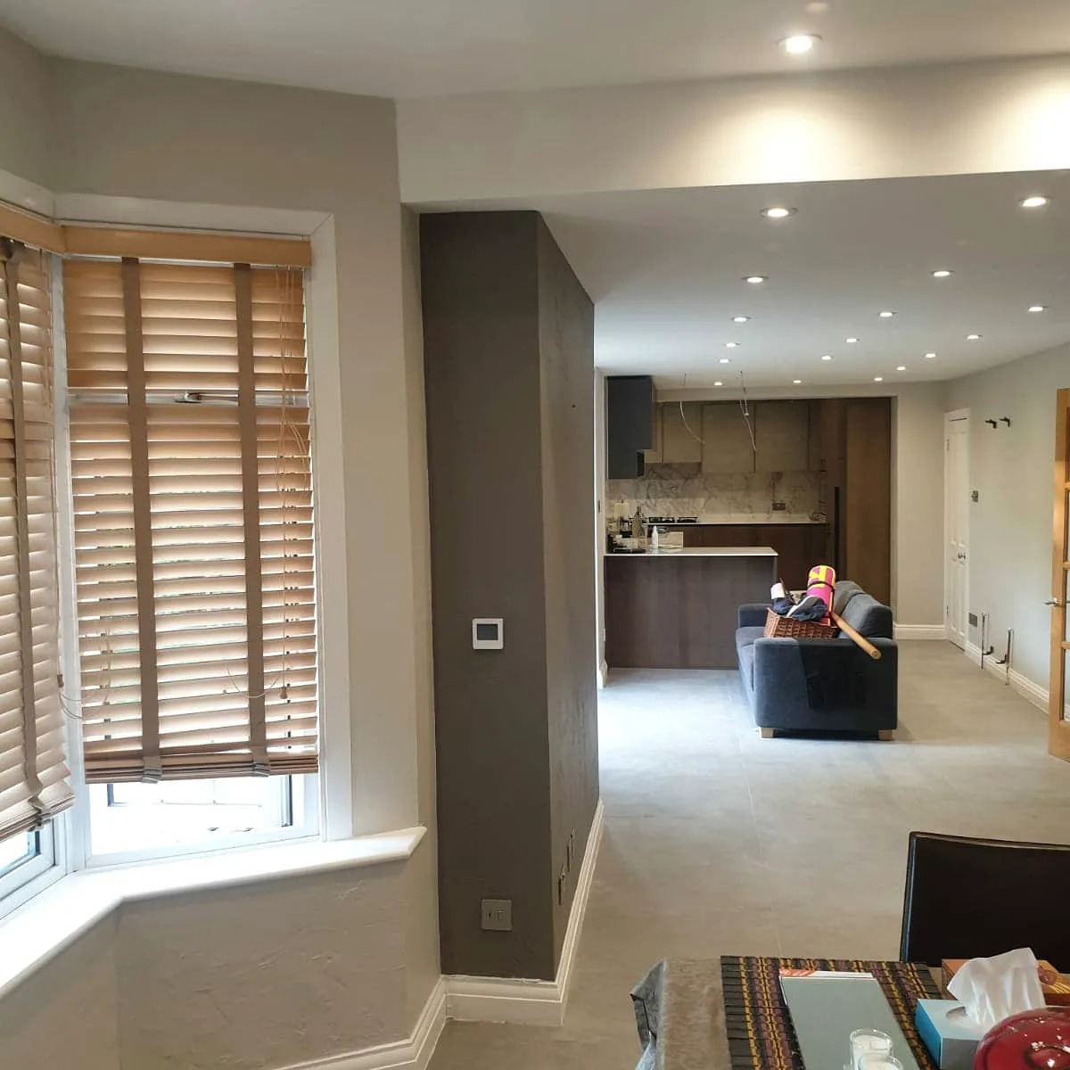 Decorated open-plan living space with feature wall and recessed lighting
